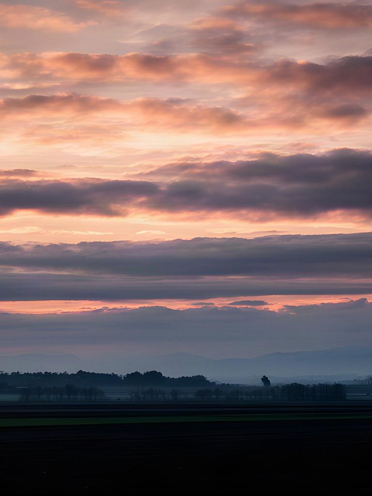 Cielo con nuvole stratificate al tramonto sopra i campi del Friuli