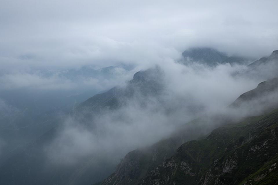 Nubi basse sulle montagne friulane con visibilità ridotta sui versanti