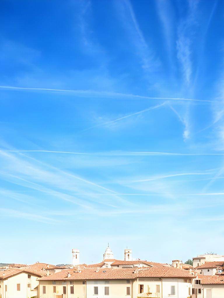 Cielo azzurro con cirri sottili sopra i tetti di Spilimbergo in una giornata limpida